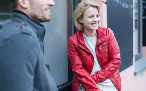 Happy Young Couple Sitting Outside Cafe