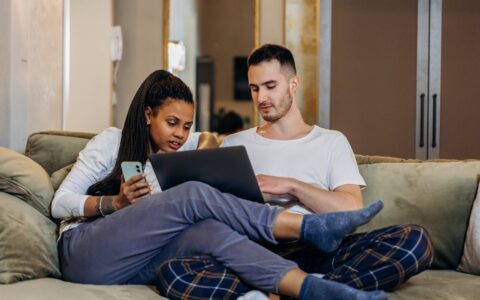 Couple sitting on the couch looking at laptop together