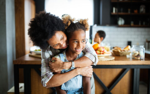 Mom and daughter hugging in the kitchen