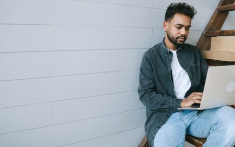 Person sitting on stairs working at his laptop