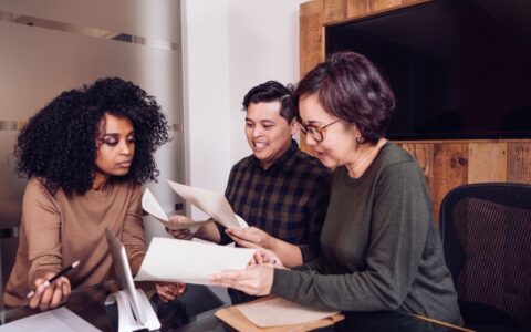 colleagues looking through paperwork together in a boardroom